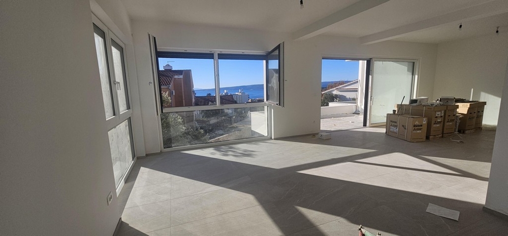 Vardagsrum med stora fönster och havsutsikt