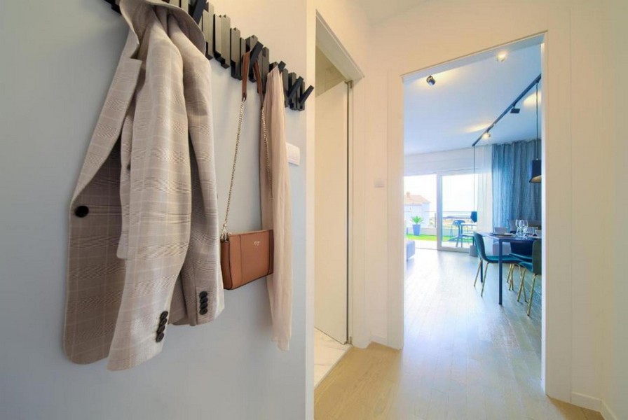 Hall med garderob och utsikt mot vardagsrummet