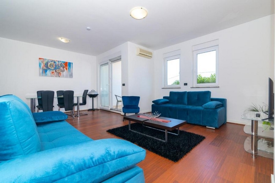 Möblerat vardagsrum med utsikt över terrassen.