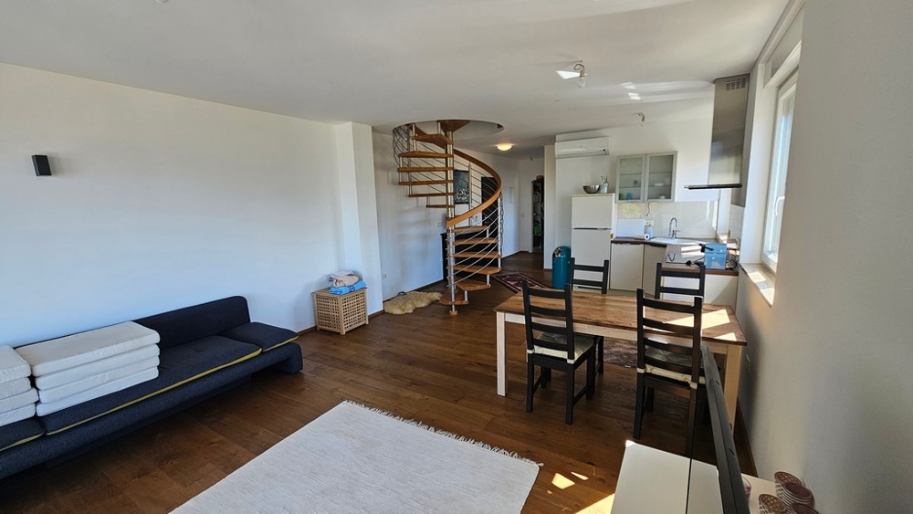 Öppet vardagsrum och matplats med kök och spiraltrappa