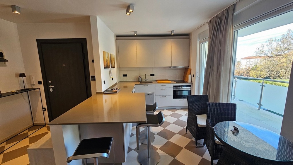 Modernt vardagsrum och kök med tillgång till balkong