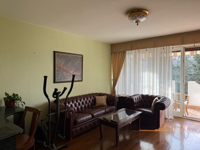 Vardagsrum med skinnsoffor och tillgång till balkong