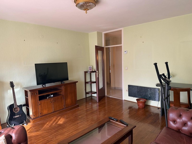 Vardagsrum med TV-möbler och parkettgolv