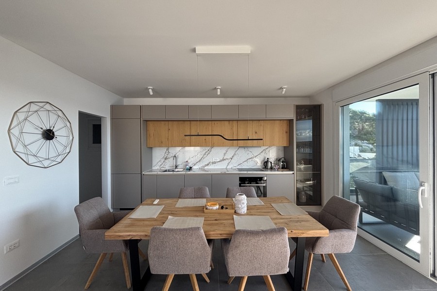 Modernt utrustat kök med matplats och stort fönsterfront