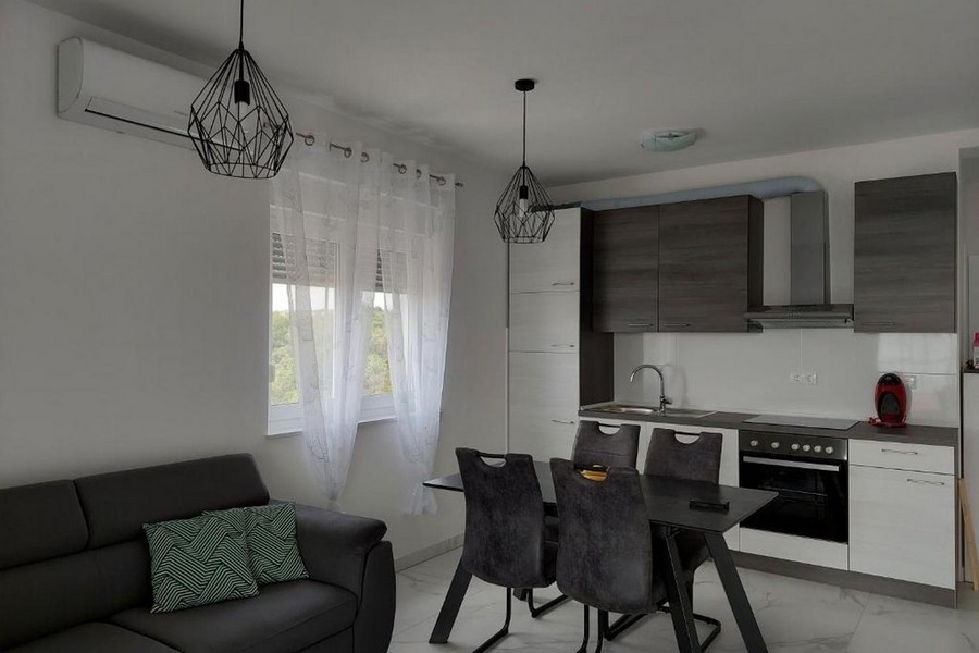 Öppet vardagsrum och kök med modernt utrustat kök och matbord