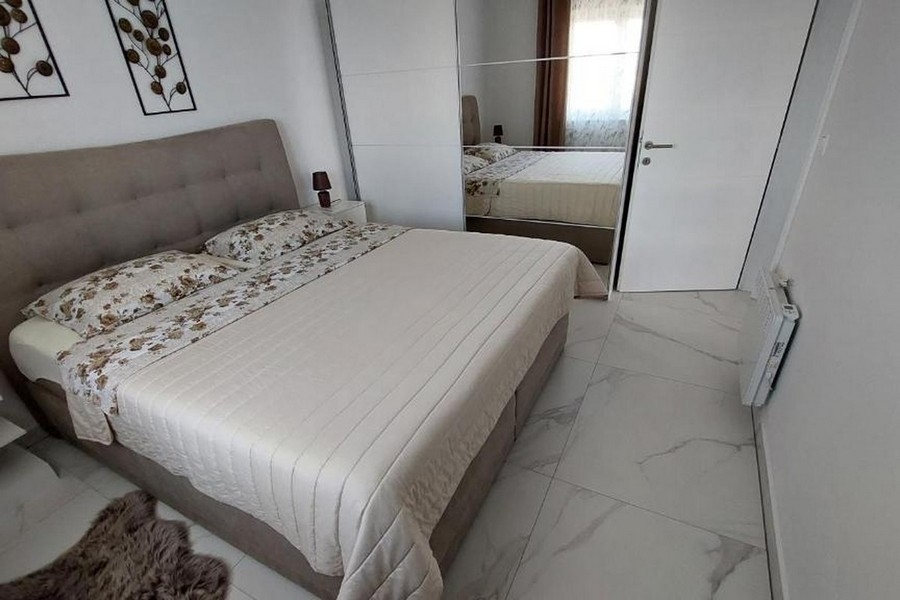 Sovrum med dubbelsäng och garderob med spegeldörrar