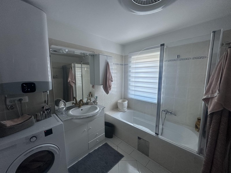 Badrum med badkar, handfat och tvättmaskin