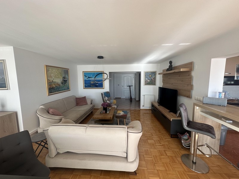 Vardagsrum med soffgrupp och öppen övergång till köket