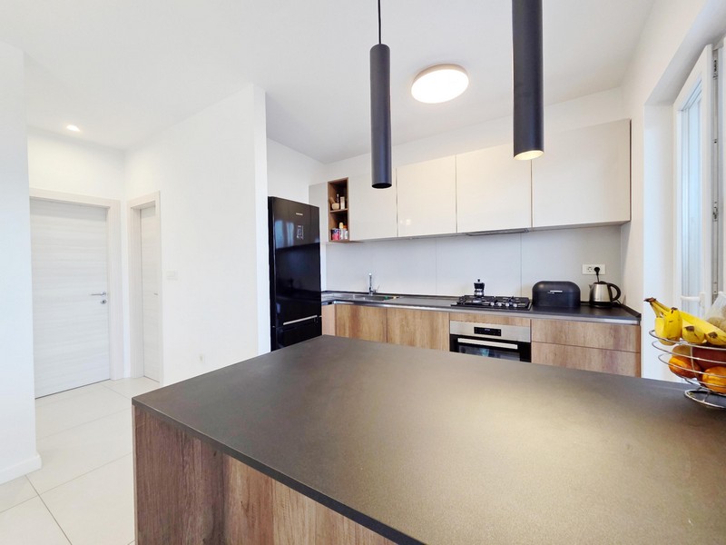 Kök med köksö och svarta hänglampor