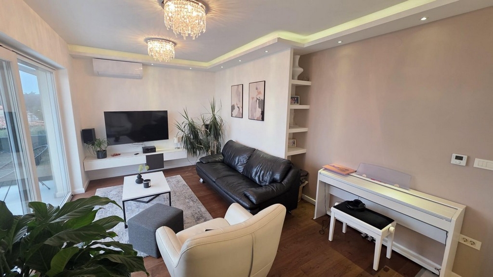 Modernt vardagsrum med skinnsoffa, luftkonditionering och indirekt belysning