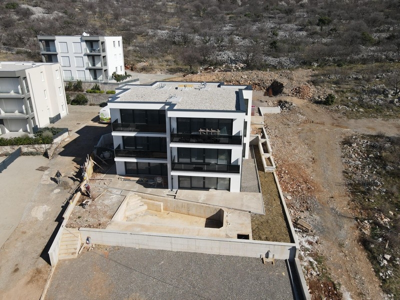 Modernt bostadsområde med balkonger och glasräcken i kustnära läge