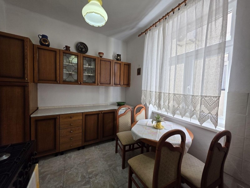 Kök med träskåp och liten sittgrupp