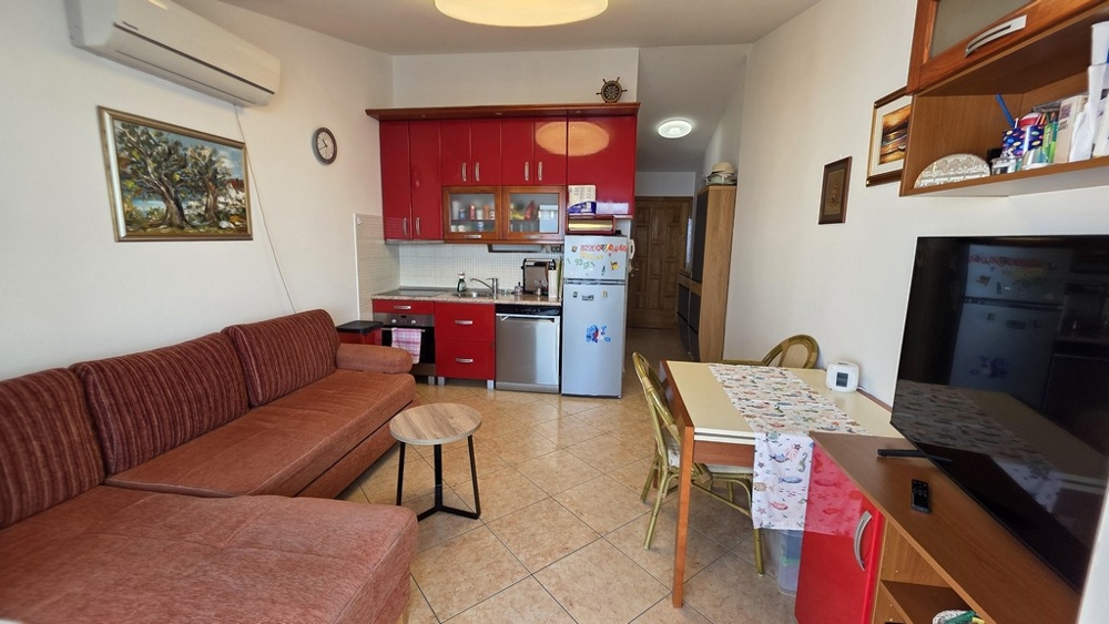 Vardagsrum med soffa och öppet kök