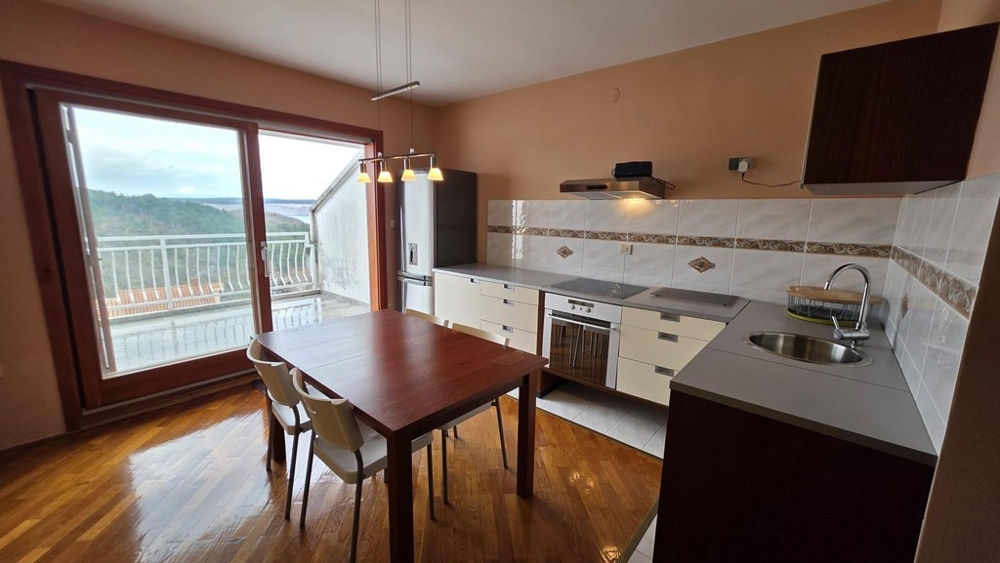 Vardagsrum med integrerat pentry och utsikt över terrassen.