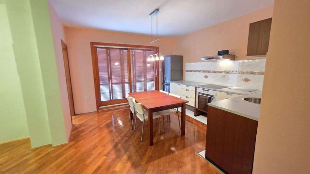 Vardagsrum med kök och matbord och utgång till balkong