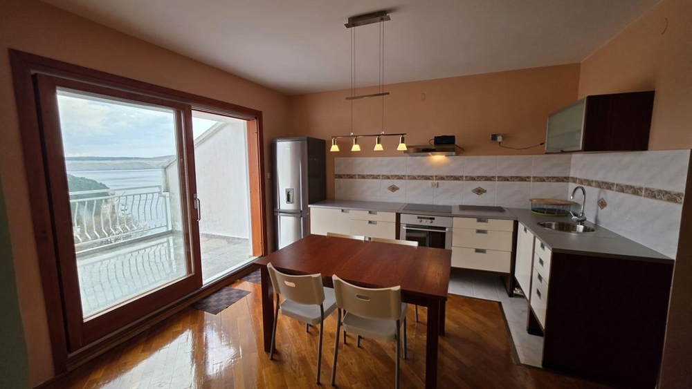 Öppet kök med inbyggda vitvaror och matplats