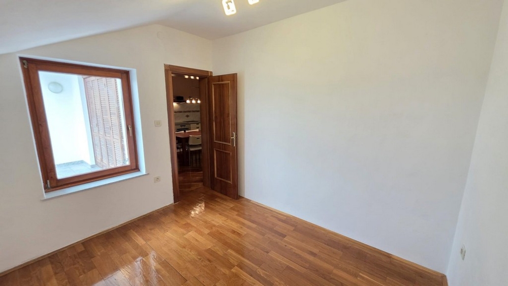 Sovrum med trägolv och fönster