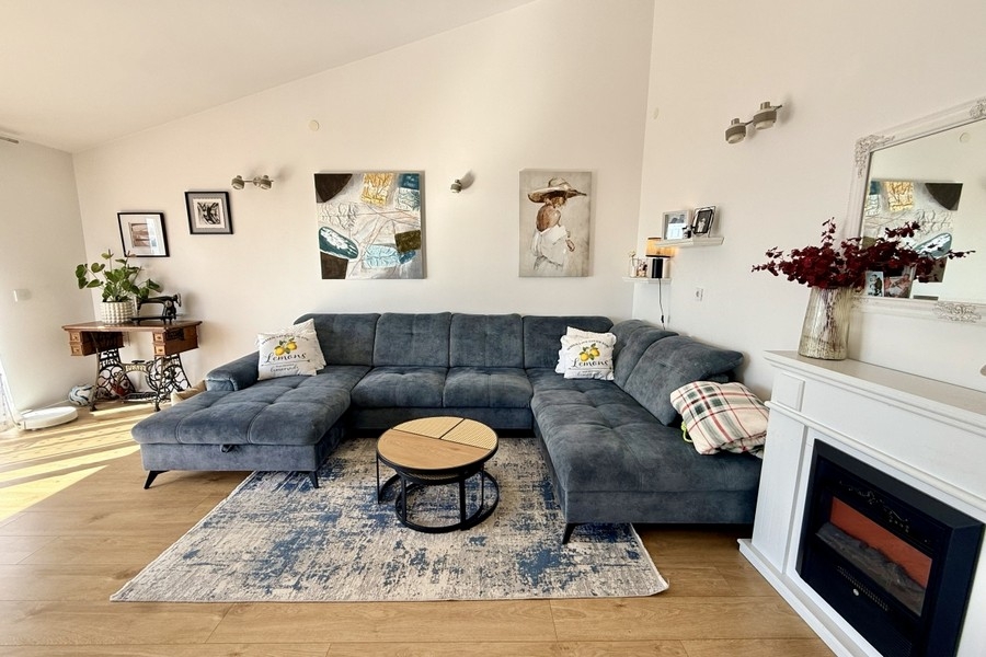 Ljust vardagsrum med stor soffa och modern atmosfär