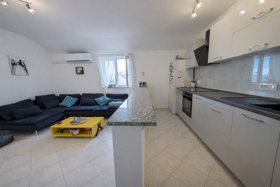 Modernt vardagsrum med öppet kök och soffa