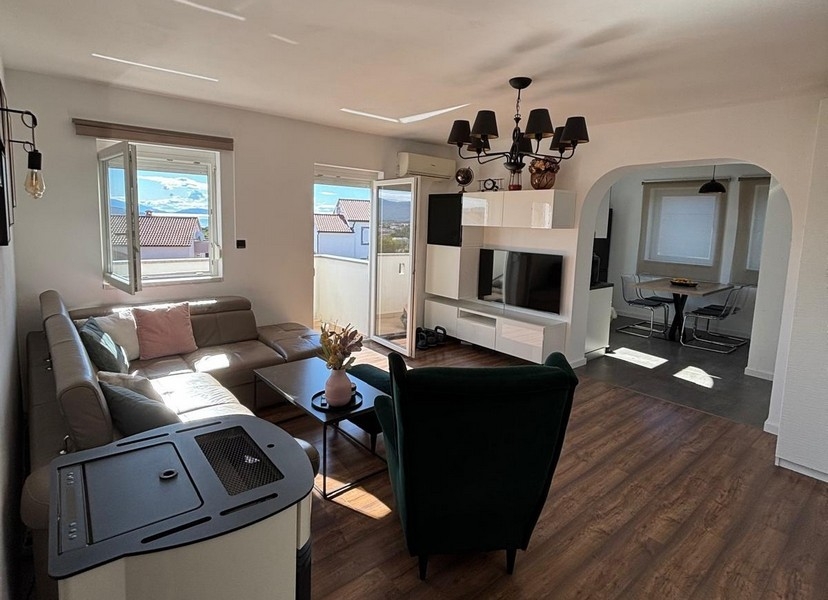 Ljust vardagsrum med modern inredning och stora fönsterpartier