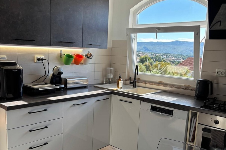 Havsutsikt från köket över hustak och kustlandskap