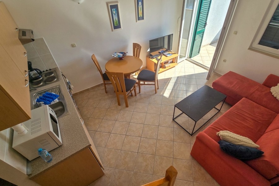 Ljust vardagsrum med öppet kök och utgång till balkong