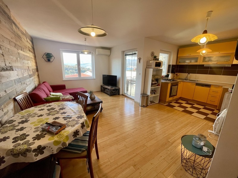 Vardagsrum med öppet kök och tillgång till balkong med havsutsikt