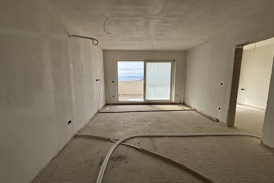 Interiörvy av öppet vardagsrum med utsikt över kök och hall