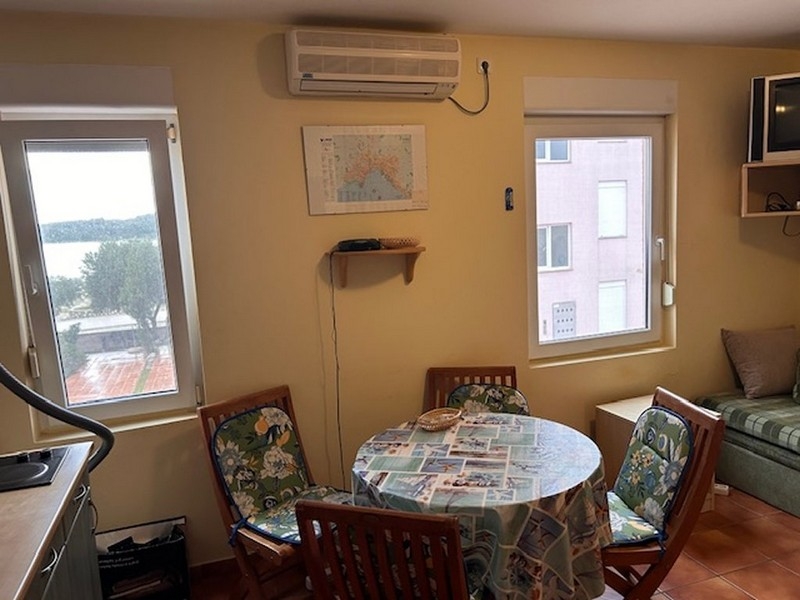 Vardags- och matplats med rundbordsgrupp och havsutsikt genom fönstret