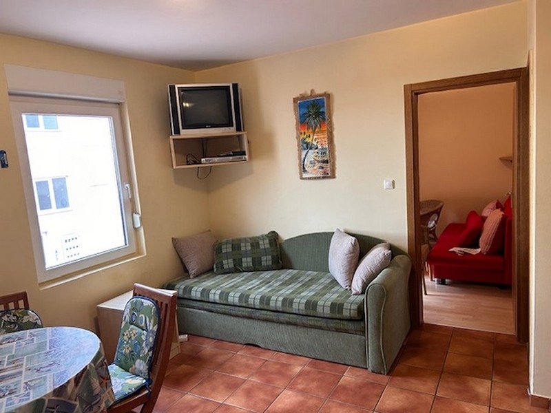 Kompakt vardagsrum med soffa, tv och tillgång till sovrummet