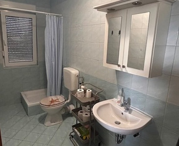 Badrum med dusch, handfat och fönster