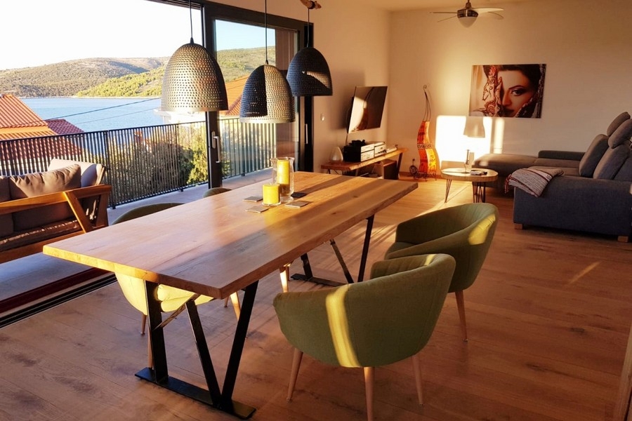 Öppet vardagsrum med soffa, matbord och utgång till balkongen