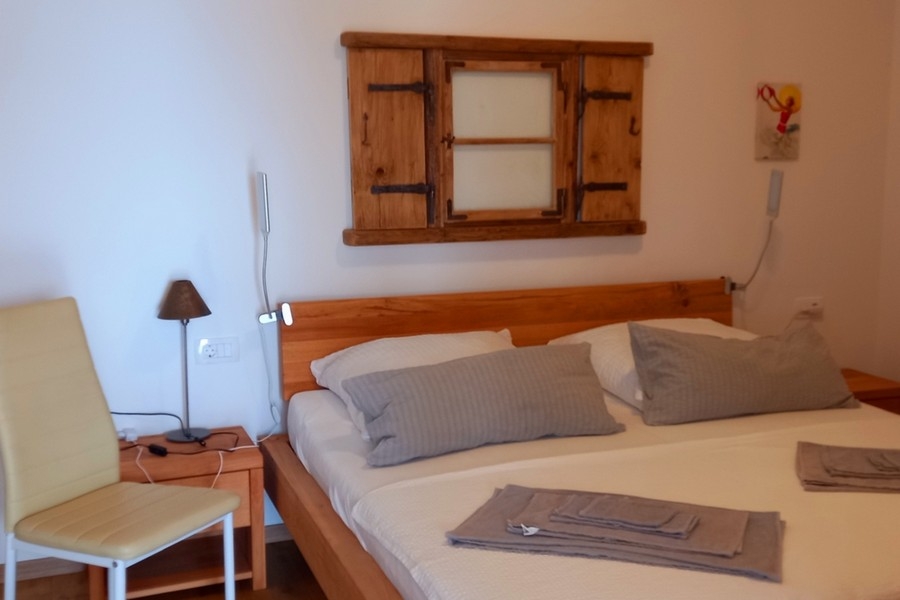 Sovrum med dubbelsäng och enkel inredning