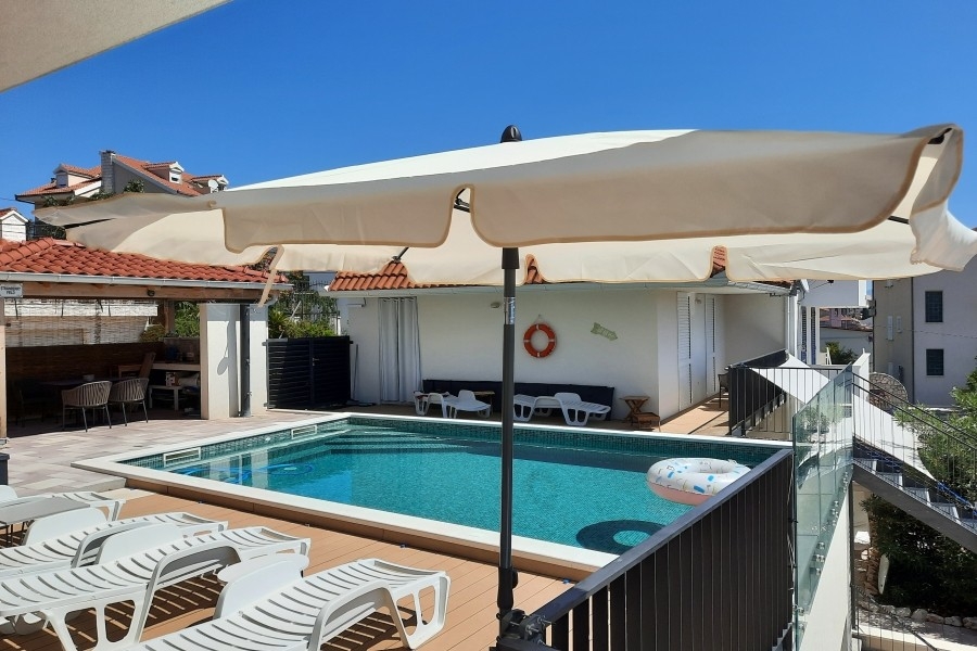 Poolområde med solterrass och solstolar