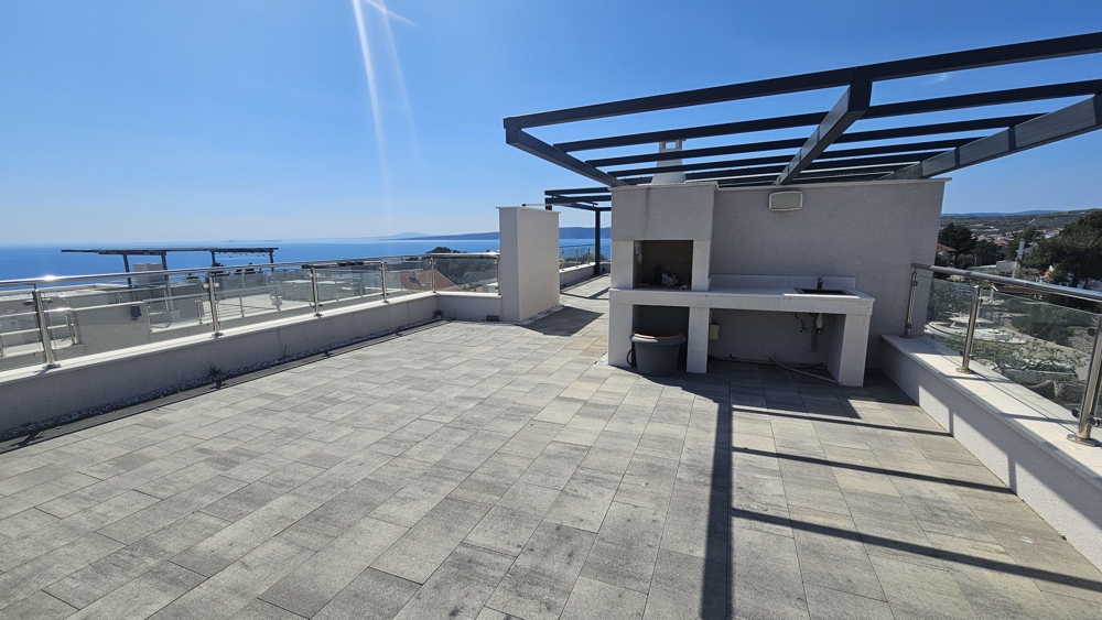 Takterrass med pergola och sommarkök och havsutsikt