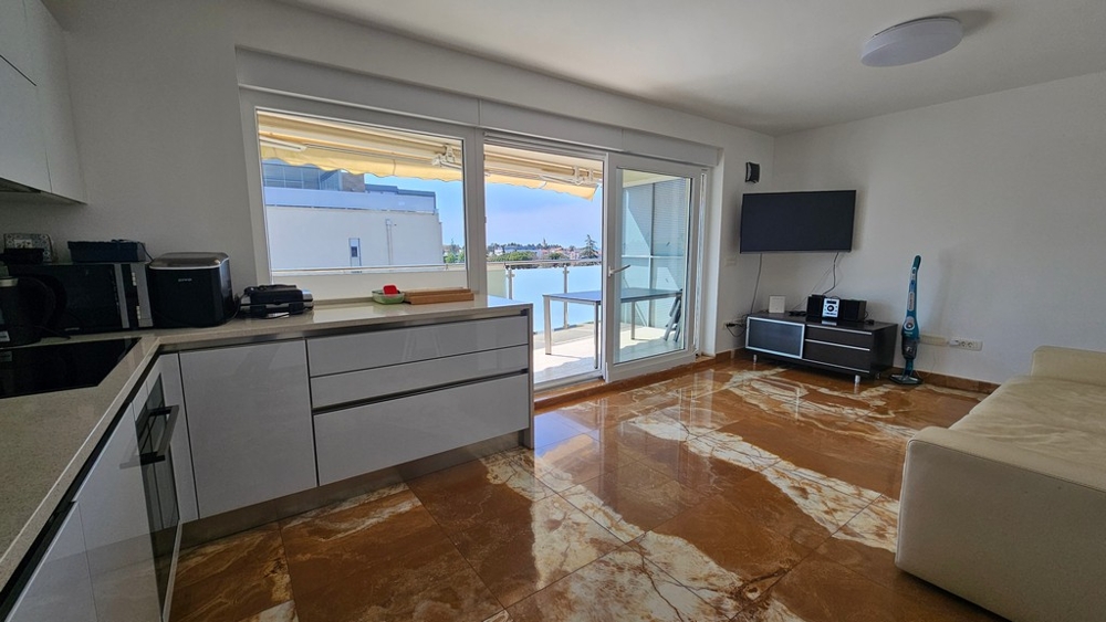 Vardagsrum med kök och tillgång till balkong med havsutsikt