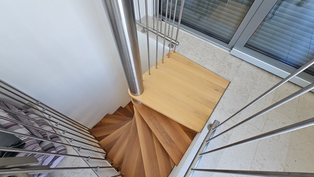 Invändig trappa med trätrappa och modernt räcke