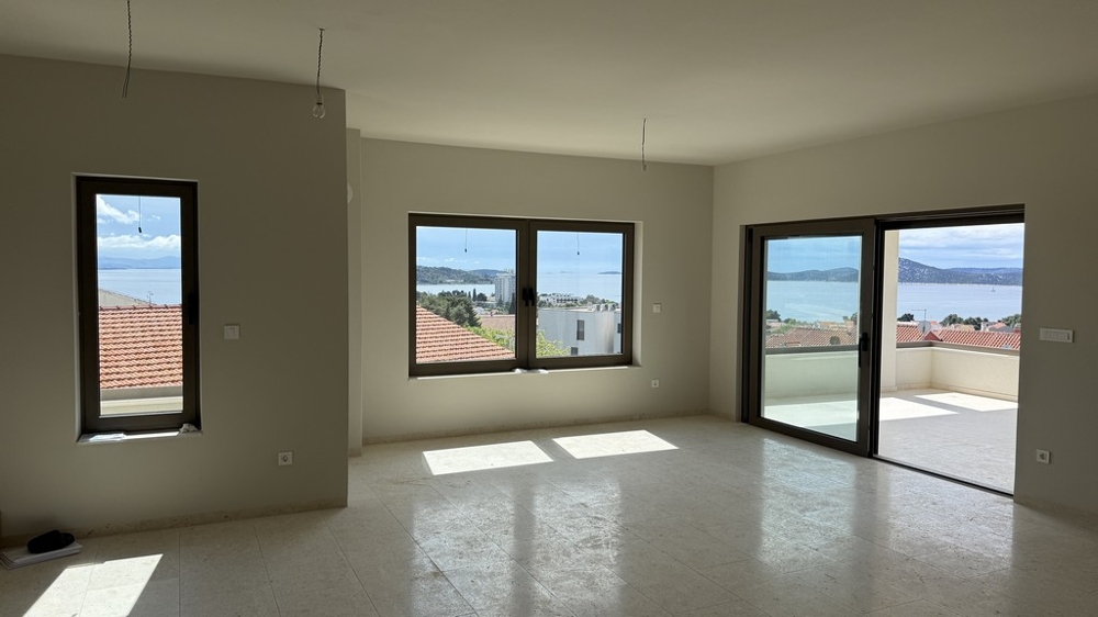 Rymligt vardagsrum med panoramafönster och havsutsikt