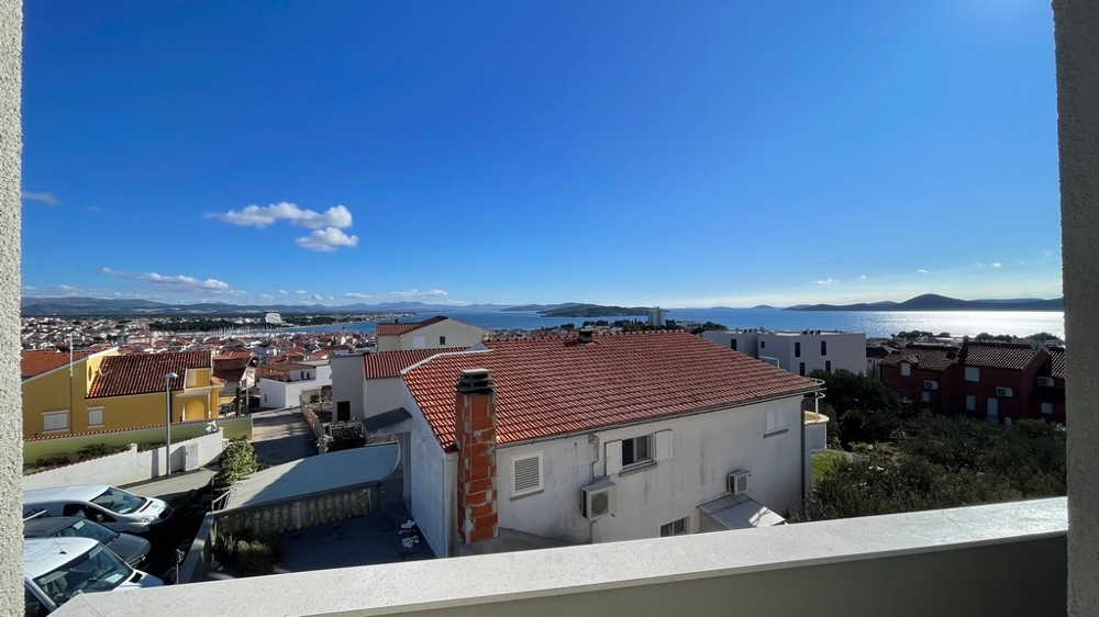 Havsutsikt från balkongen över hustaken och kusten