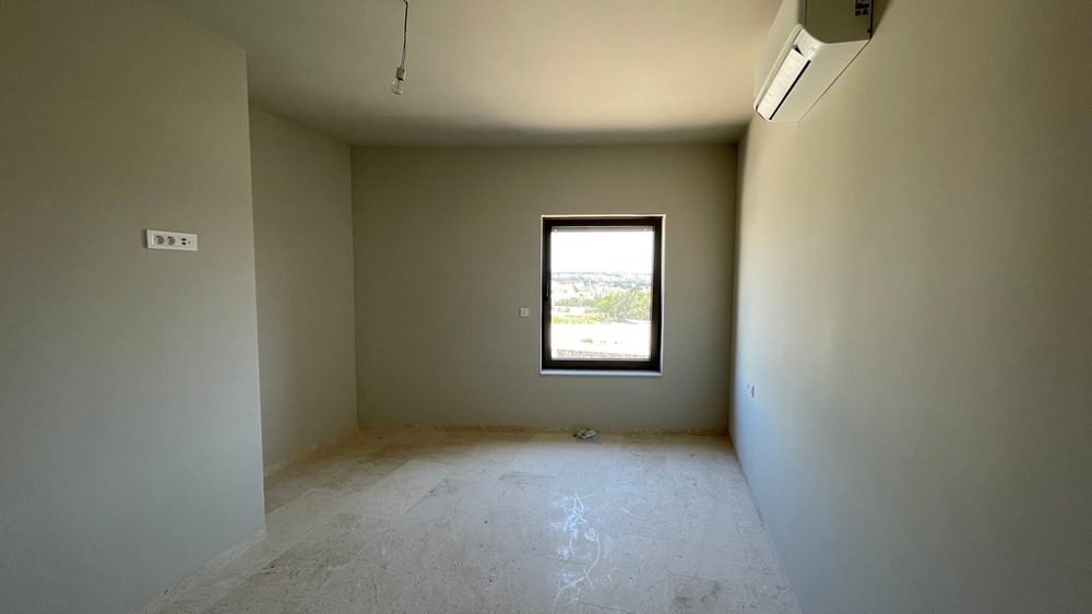 Sovrum med luftkonditionering och delvis skymd havsutsikt