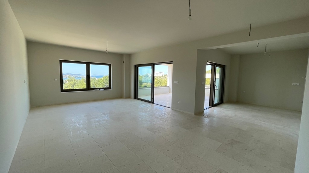 Ljust öppet vardagsrum med stora fönster och havsutsikt