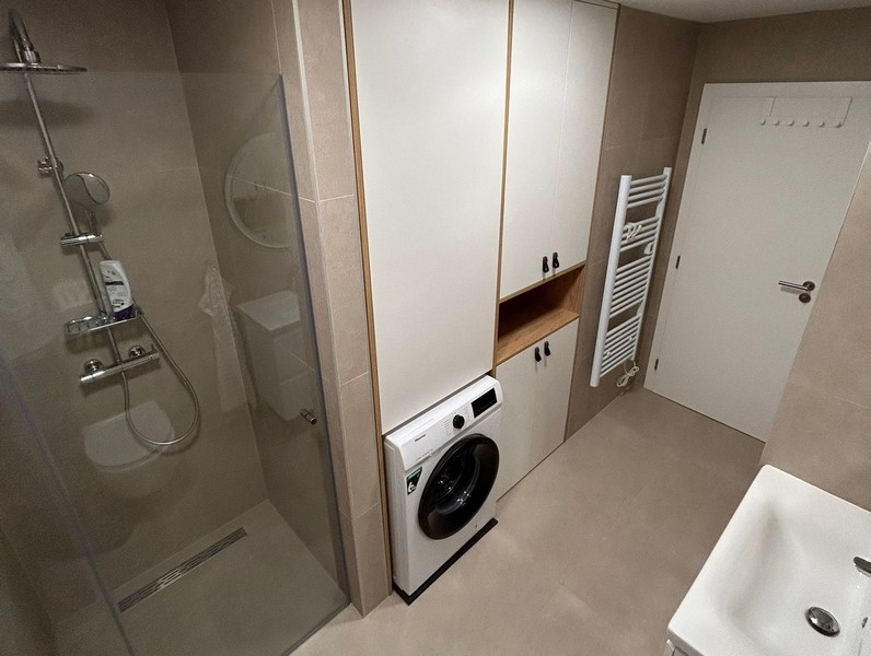 Badrum med dusch, tvättmaskin och inbyggd garderob
