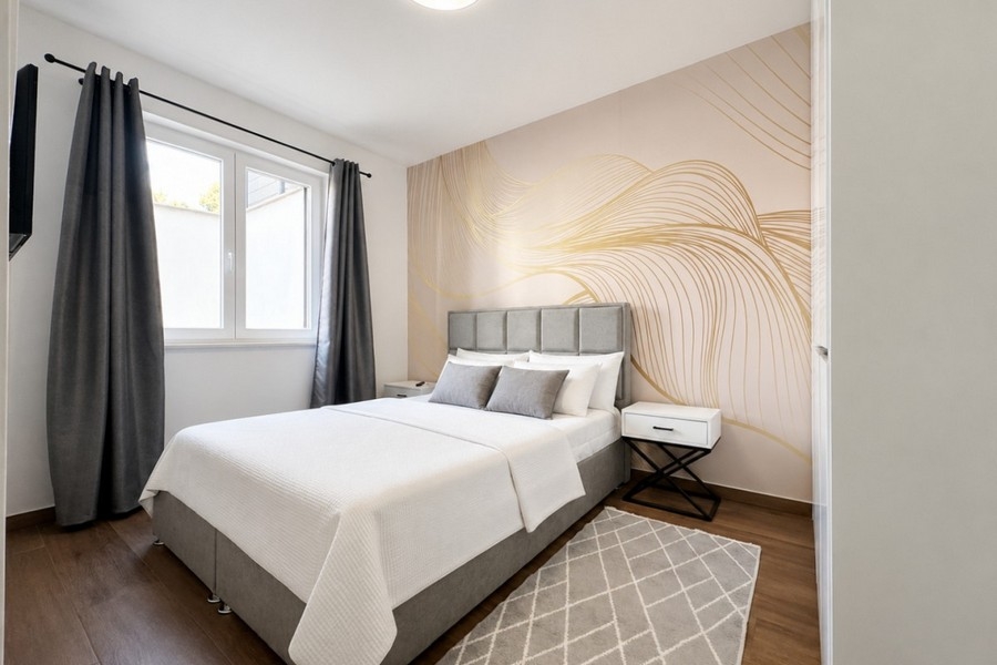 Modernt sovrum med stilren väggdesign och TV