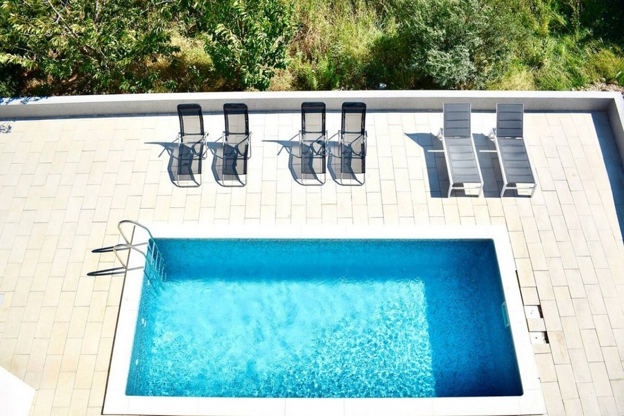 Fågelperspektiv över privat pool med solterrass