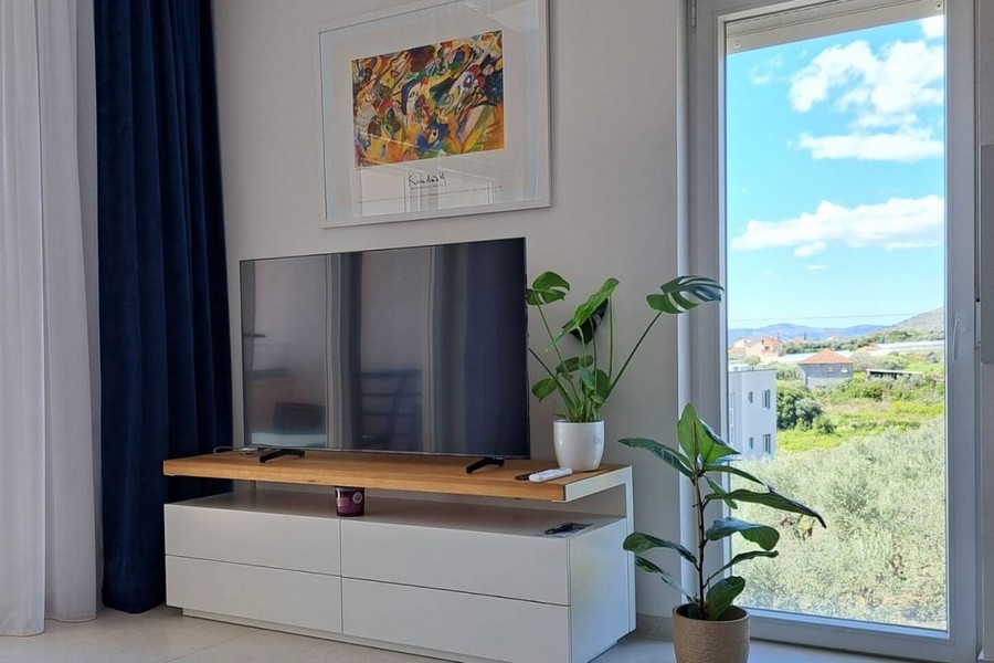 Vardagsrum med TV och stora fönster
