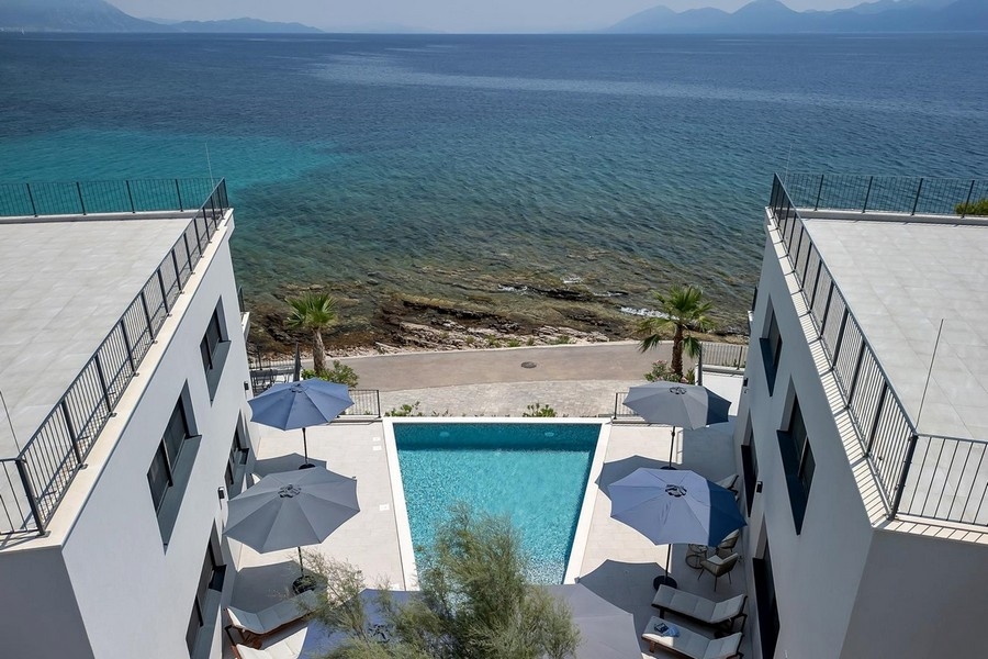 Flygfoto över lägenhet med pool vid havet