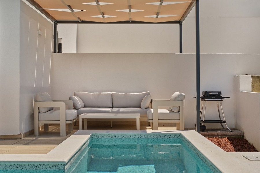 Täckt terrass med sittgrupp vid poolen