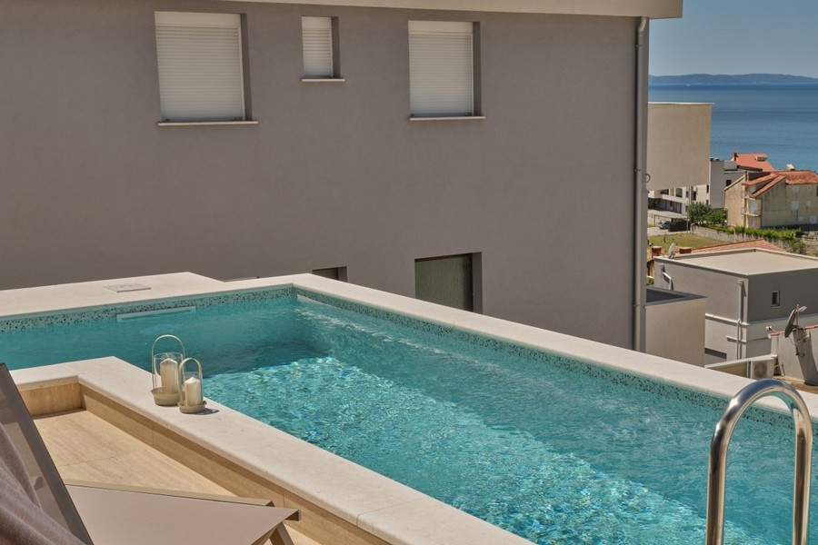 Pool med villafasad och havsutsikt i Kroatien