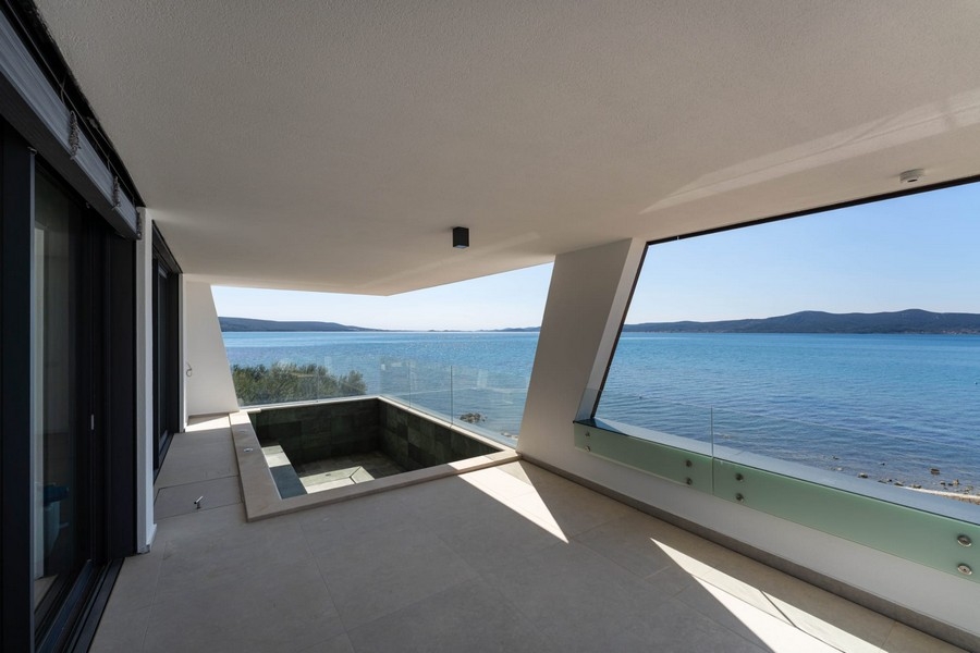 Täckt terrass med pool och panoramautsikt över havet