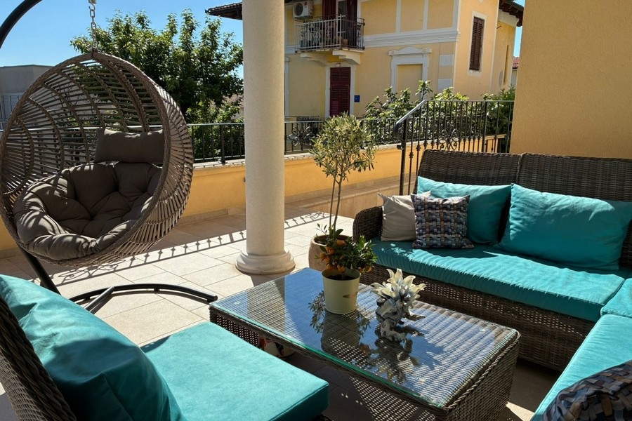Terrass med loungemöbler och hängstolar i Kroatien